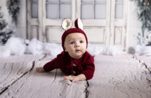 Christmas mini photoshoot of baby with parents in festive studio setting