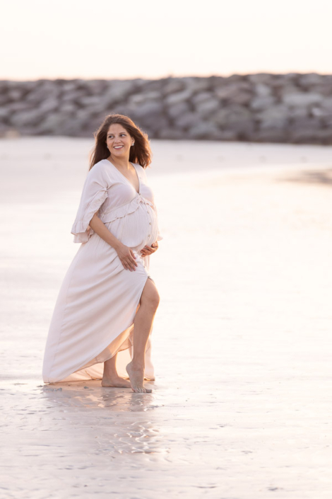 Couple walking during sunset maternity shoot at Al Sufouh Beach Dubai