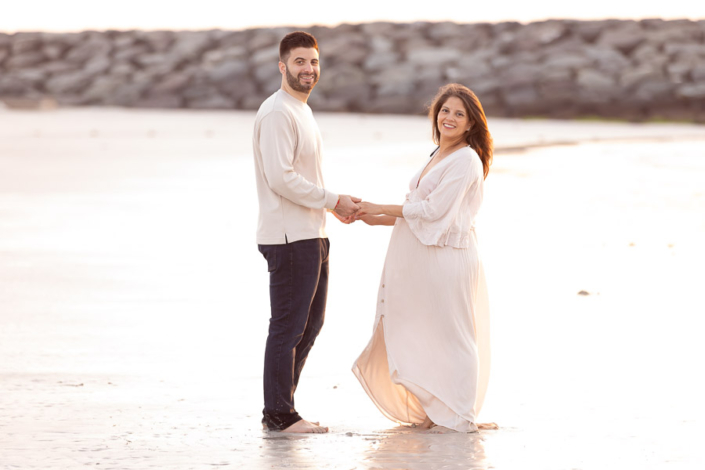 Flowing dress maternity photoshoot at Dubai beach with dramatic sunset sky