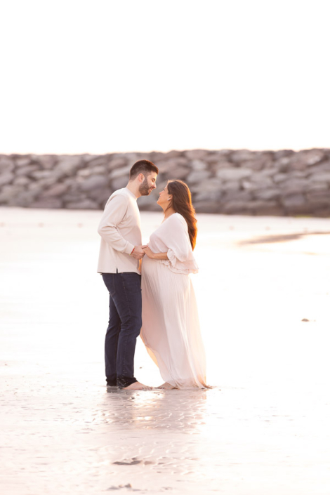 Luxury beach maternity photoshoot Dubai with flowing designer gown by the ocean