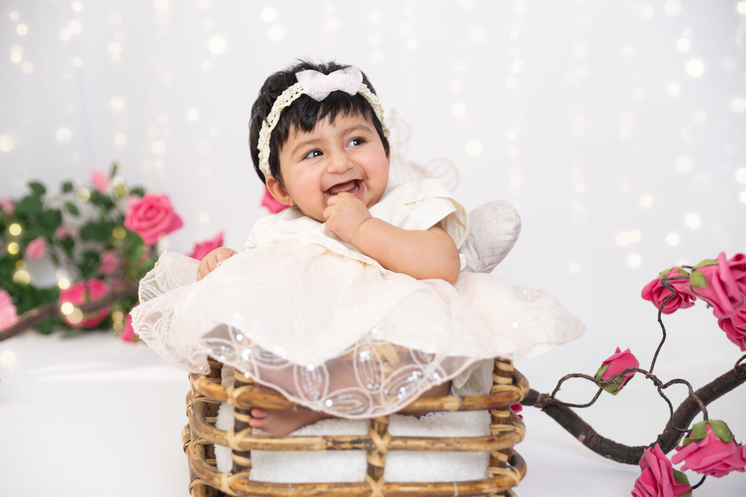 Smiling baby girl in white dress during baby photography in Dubai