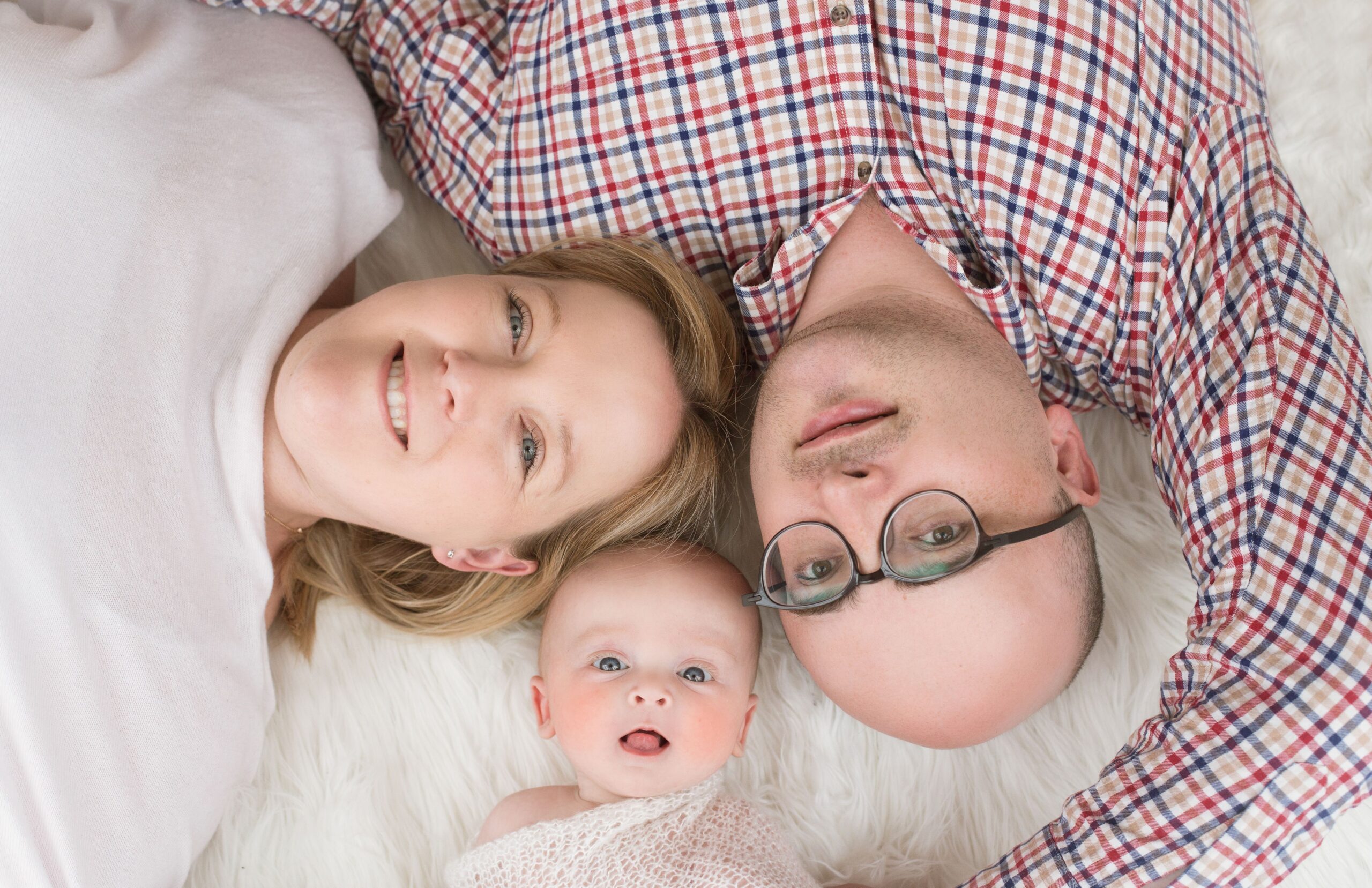Baby lying between parents during a baby photography session in Dubai