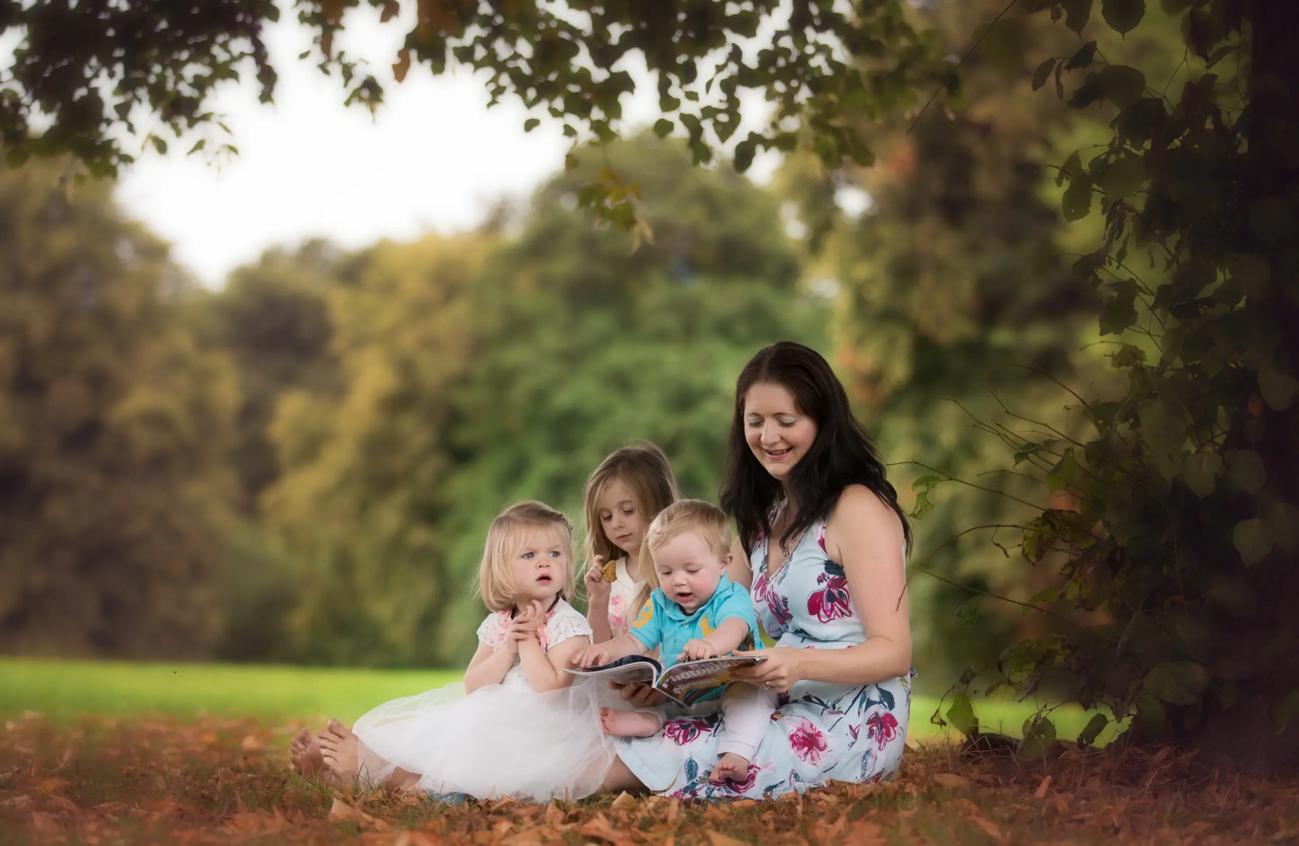 mother sitting with her kids outside in a park