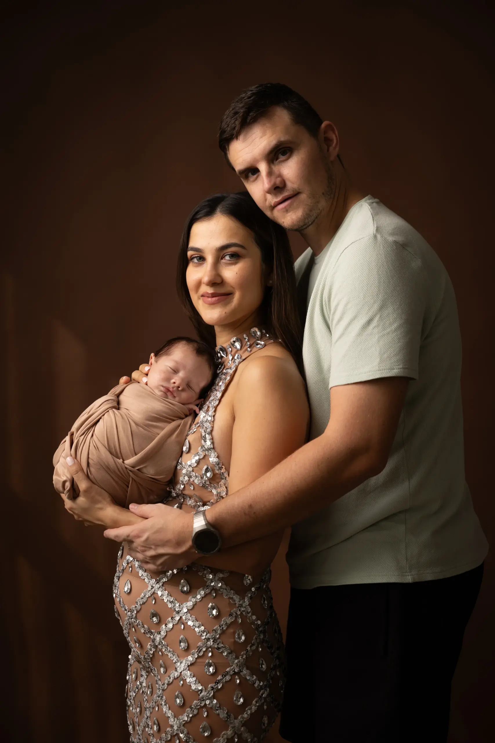 Professional newborn photographer safely supporting a baby during posing