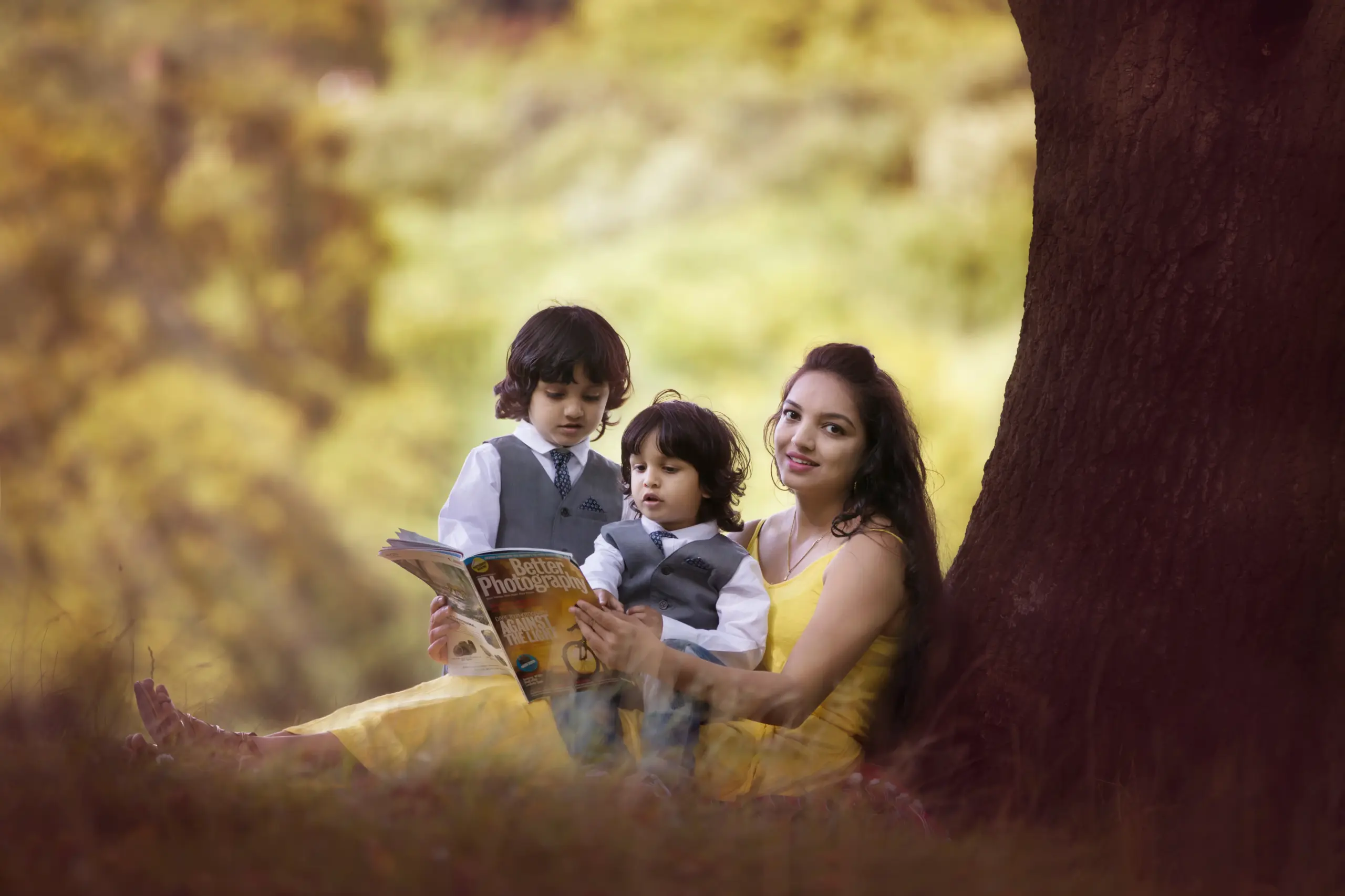 mother with her kids sitting under tree