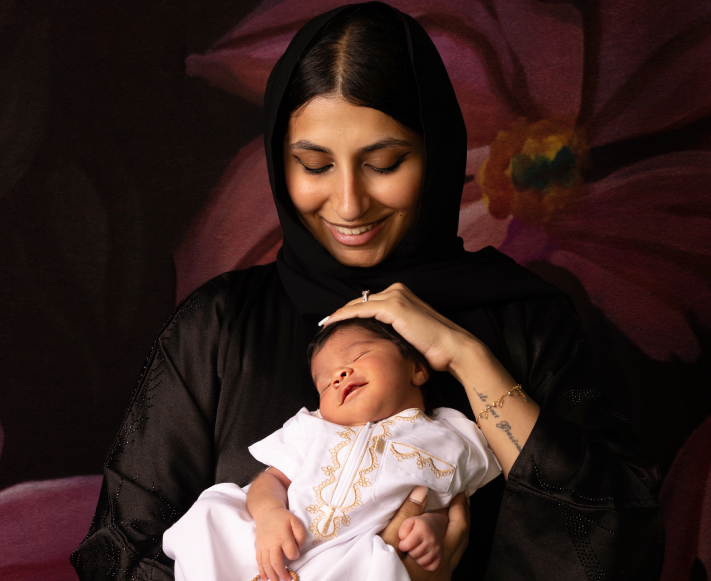 Mother holding newborn baby with a newborn photographer in Dubai