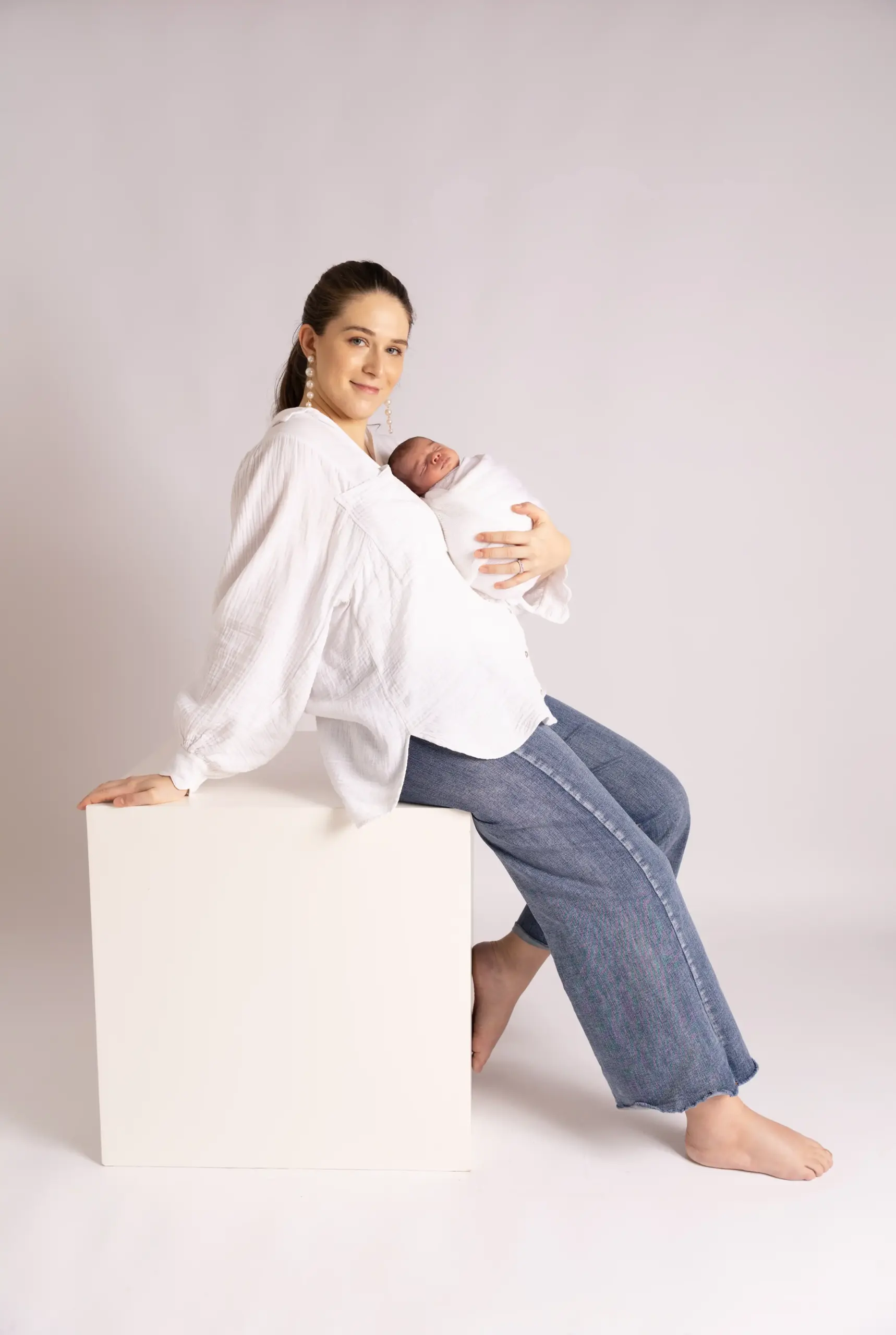 Mother cuddling newborn baby during newborn photography in Dubai