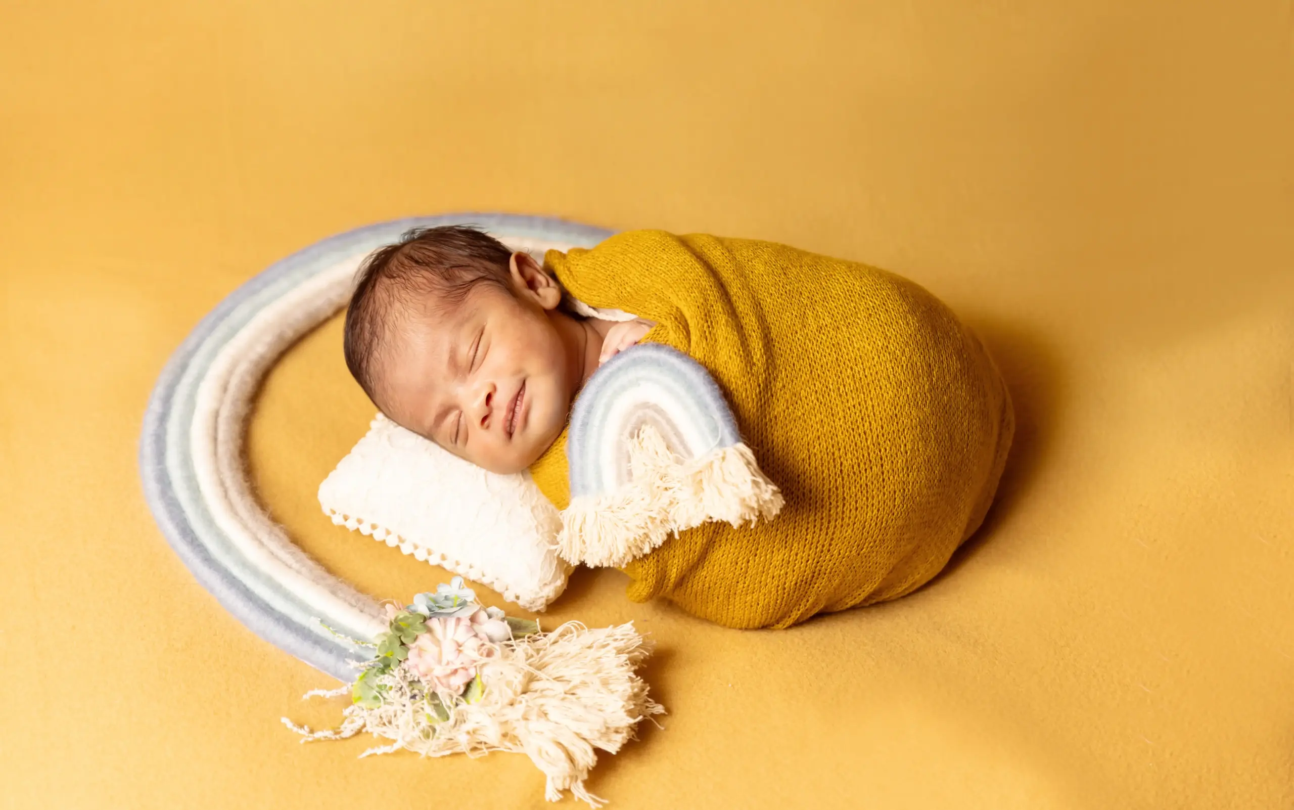 Newborn baby in a colorful setup by a newborn photographer in Dubai