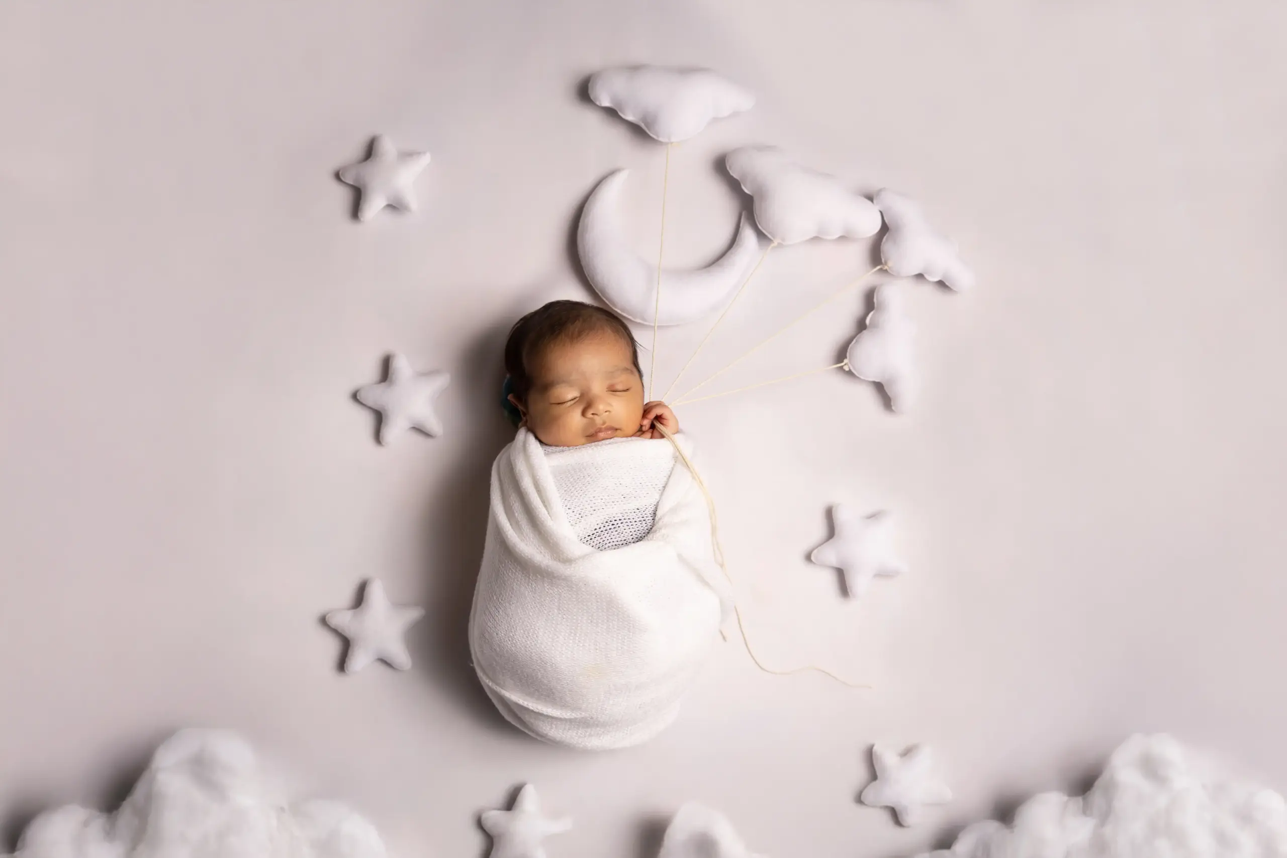 Newborn baby in a moon-themed setup during newborn photography in Dubai