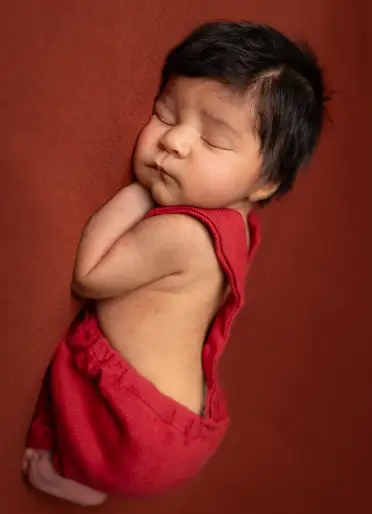 Safe newborn photography setup with soft fabrics and supported props